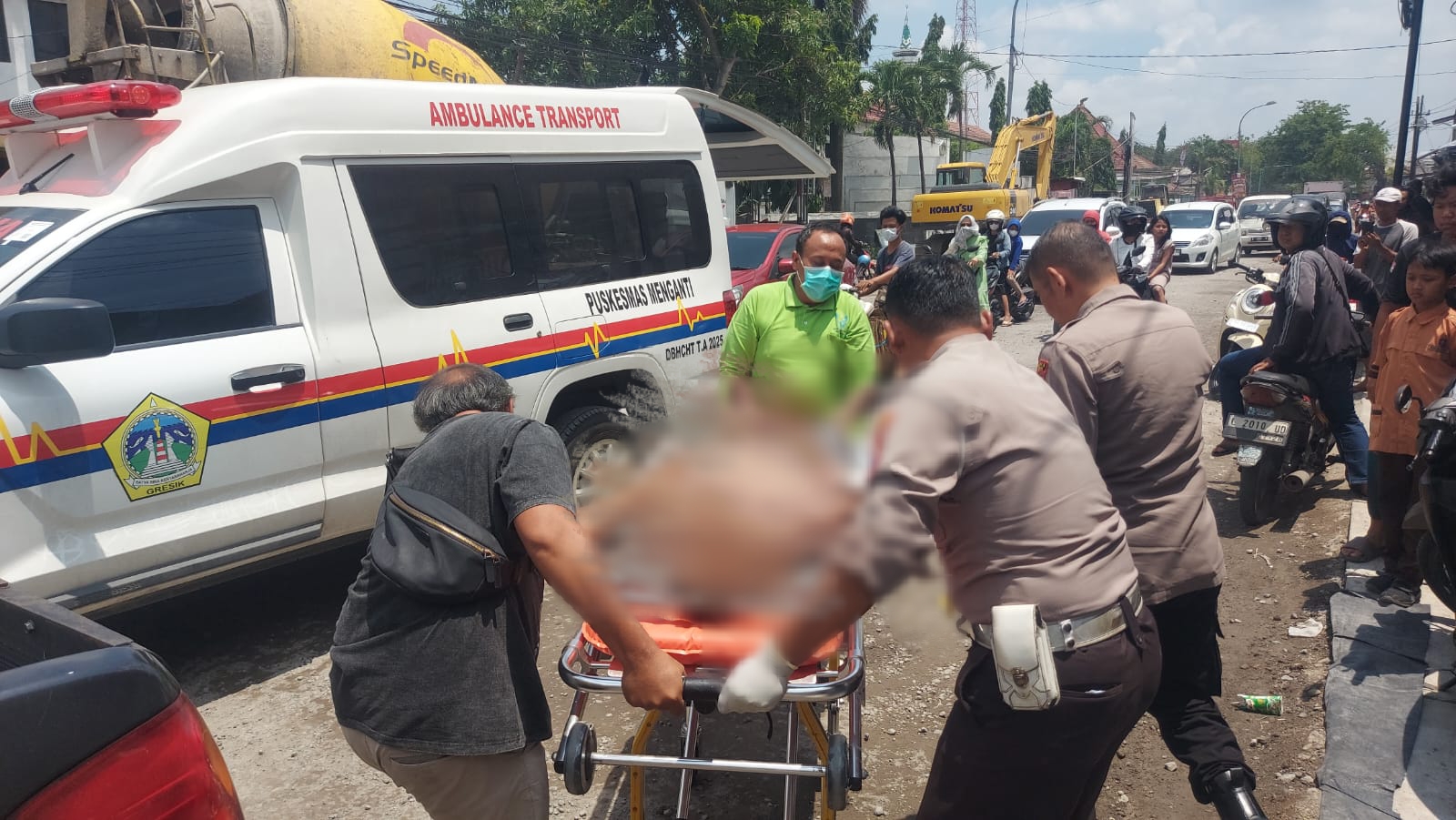 DIEVAKUASI : Anggota Polsek Menganti dibantu tim medis dan warga saat meng vakuasi korban MrX untuk dibawa ke RSUD Ibnusina Gresik.