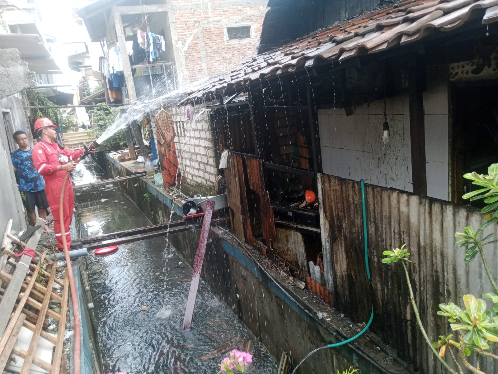 PEMADAMAN : Petugas Damkar Kabupaten Gresik saatbmelakukan pemadaman kebakaran di rumah warga Jalan Gubernur Suryo Gg. 10 No. 14, RT 02 RW 05, Kecamatan Gresik.
