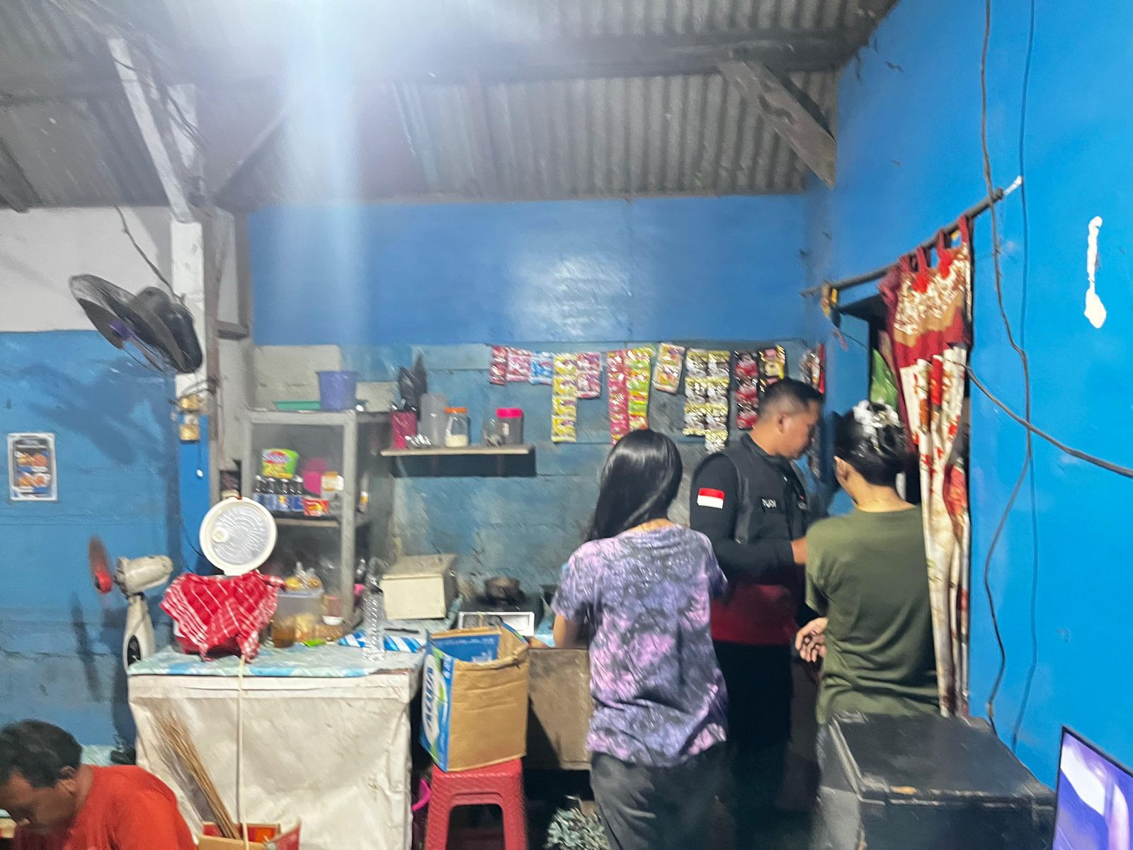 DIAMANKAN : Anggota Polres Gresik saat mengamankan puluhan botol miras dari sebuah warung karaoke di wilayah Kecamatan Menganti.