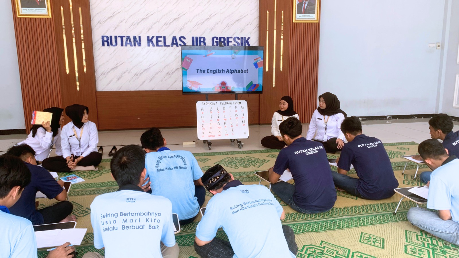 TINGKATKAN LITERASI : Petugas Rutan kelas IIB Gresik saat mendapinginwarga binaan untuk belajar literasi dasar membaca dan menulis.