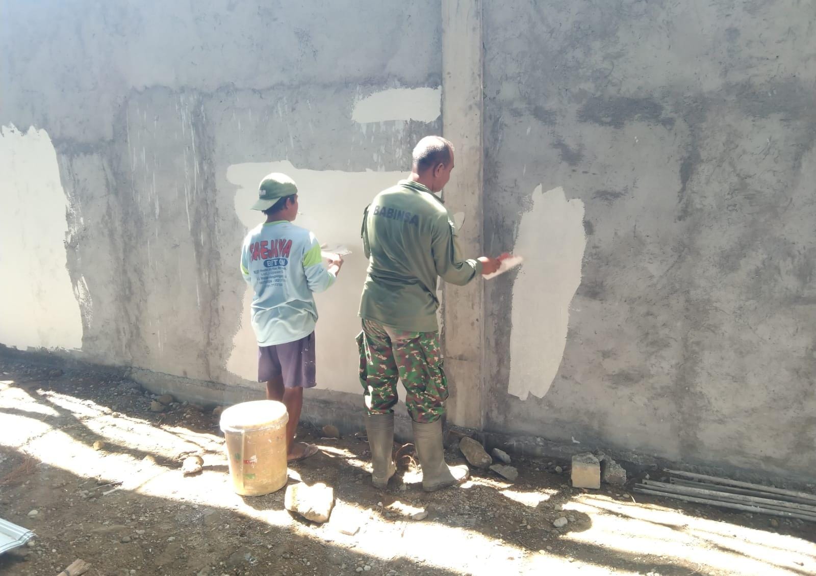 BANTU : Anggota TNI membantu warga dalam mempercepat pembangunan KDKMP di desa.