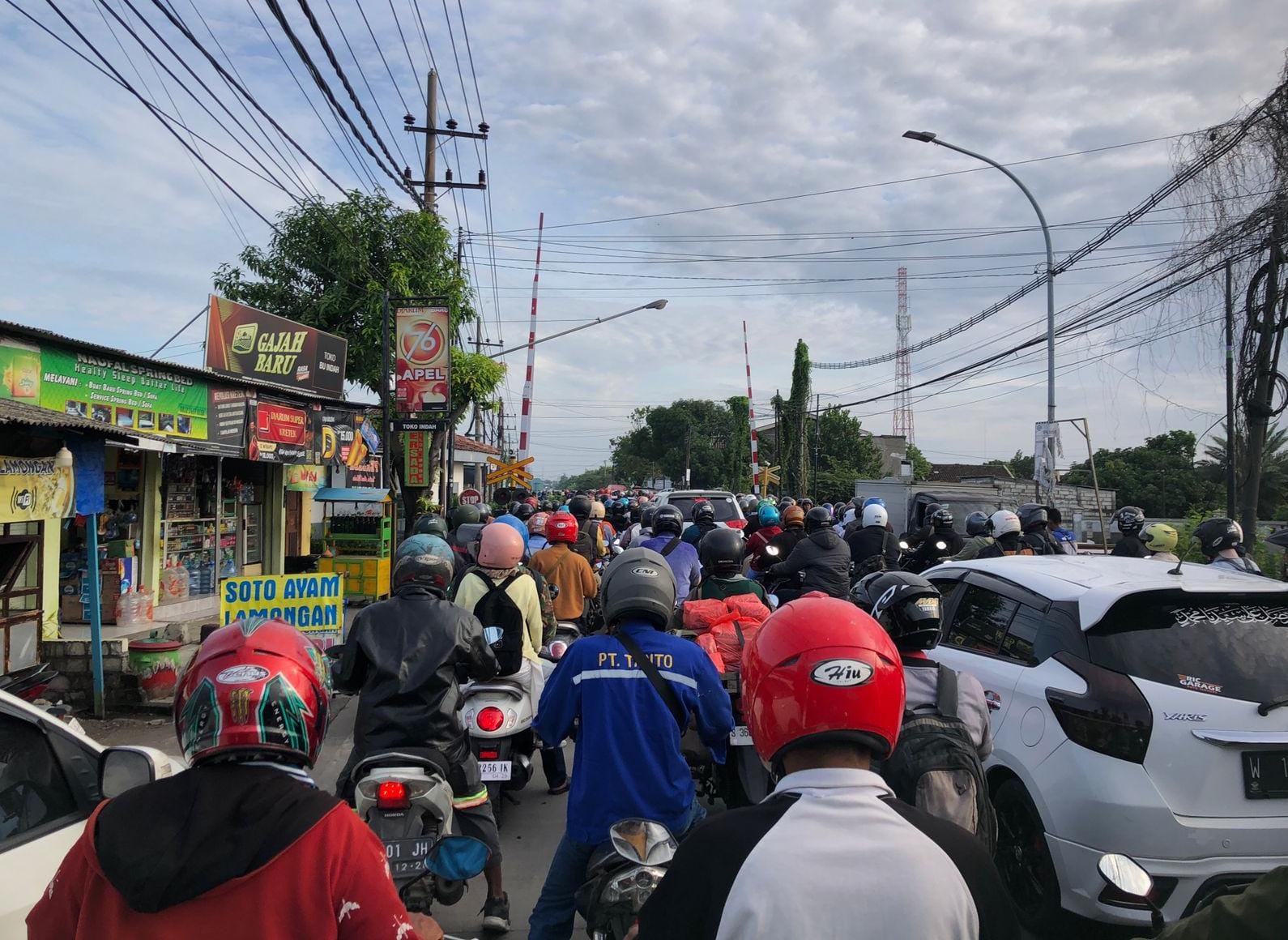 PARAH: Antrean kendaraan roda dua dan roda empat saat terjebak macet di perlintasan KA Jalan Raya Cerme Lor, Gresik.