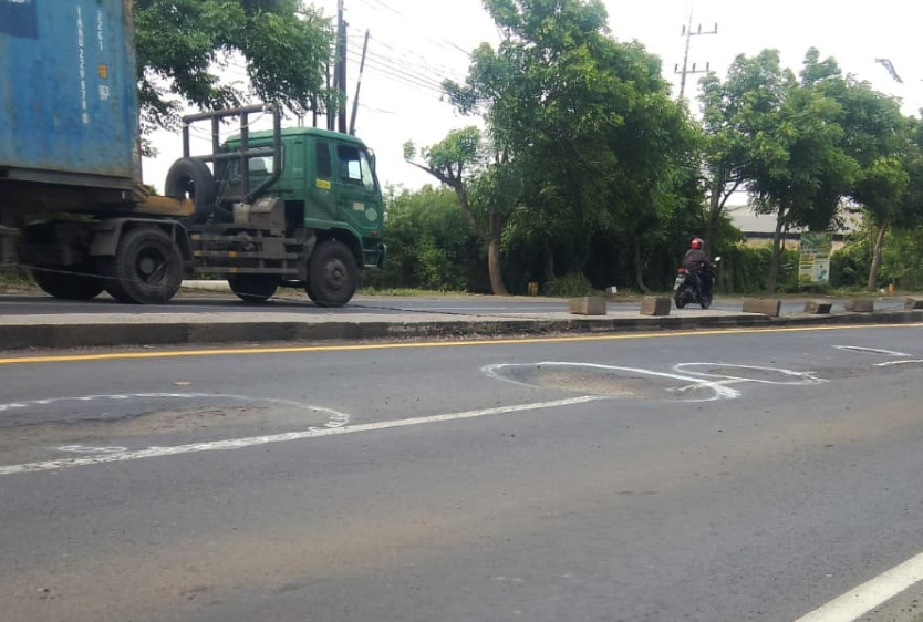 BERLUBANG: Kerusakan terlihat jelas pada permukaan aspal di Jalan Trosobo yang amblas, berlubang dalam, dan bergelombang, terutama di jalur cepat.