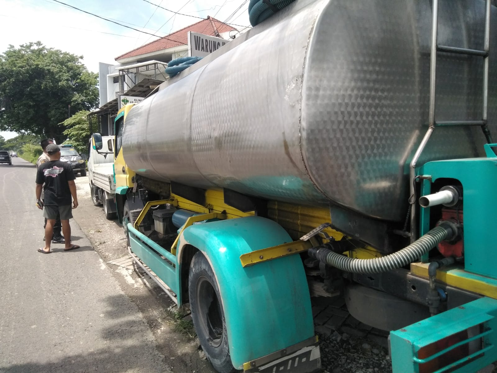 DIAMANKAN: Petugas kepolisian saat melakukan olah TKP dan mengamankan kendaraan truk tangki serta motor yang terlibat kecelakaan di depan Klinik Ar. Rochmah, Jalan Raya Jatirembe, Benjeng.