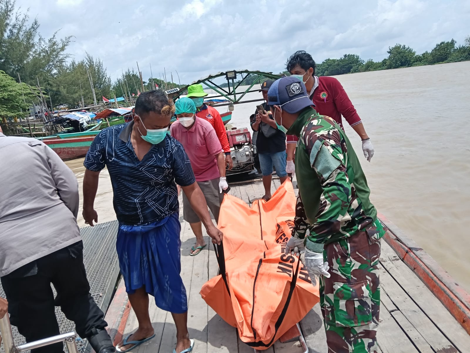 DIEVAKUASI : Anggota Polsek Sidayu dibantu tim medis dan anggota Koramil saat mengevakuasi mayat seorang pria ditemukan mengambang di Sungai Bengawan Solo.