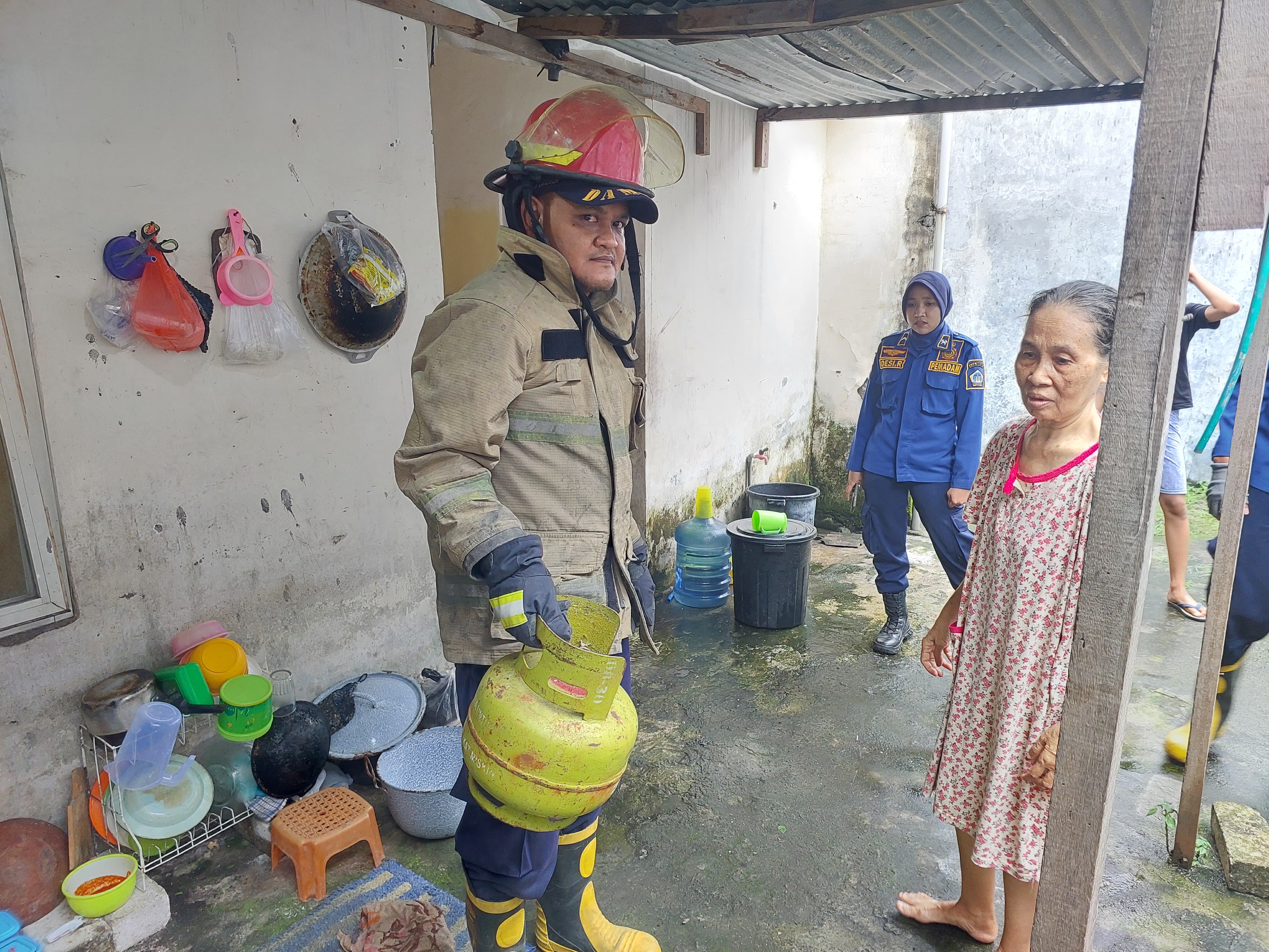 DITANGANI : Petugas Damkar Pos Menganti Gresik saat memadamkan kebocoran gas elpiji milik warga di Perumahan Puri Asta Kencana,