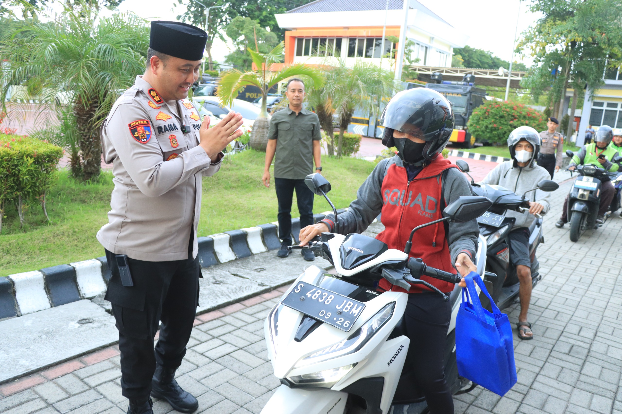 BERBAGI :   Kapolres Gresik, AKBP Ramadhan Nasution didampingi Wakapolres Gresik Kompol Shabda Purusha Putra beserta Bhayangkari dan jajaran Polres Gresik saat memberikan takjil ke ojol dan pengendara