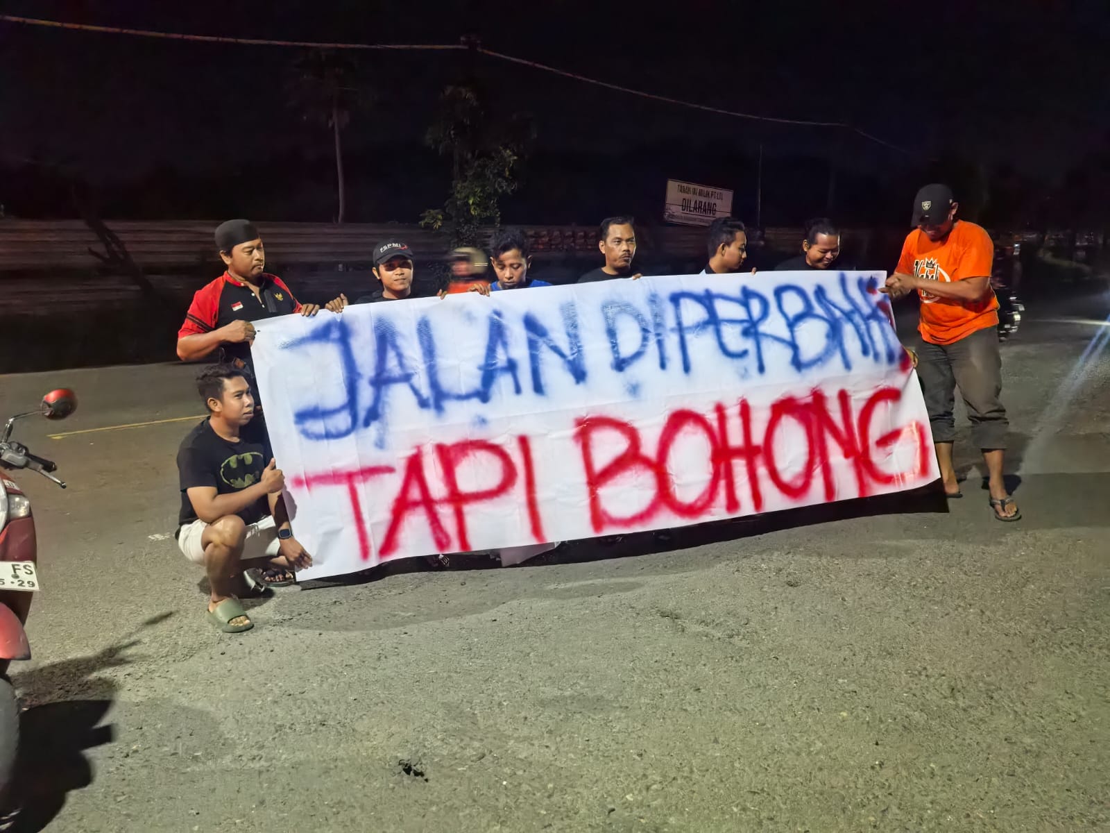 PROTES : Sejumlah warga Kecamatan Manyar saat memasang spanduk bertuliskan protes akibat kondisi jalan nasional yang rusak parah diwilayah Kecamatan Manyar, Gresik.