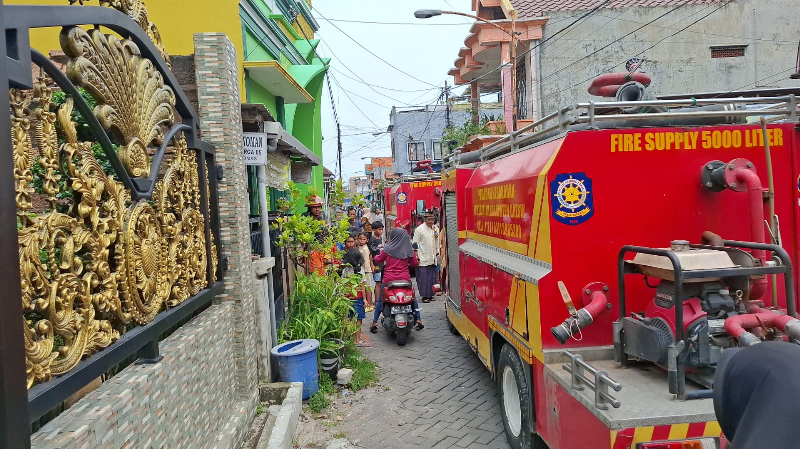 Petugas Damkar Gresik saat melakukan pemadaman kebaran di Jalan Dr. Wahidin Sudiro Husodo 1A No. 27, RT 2/RW 5, Kelurahan Kebomas, Kecamatan Kebomas, Gresik.