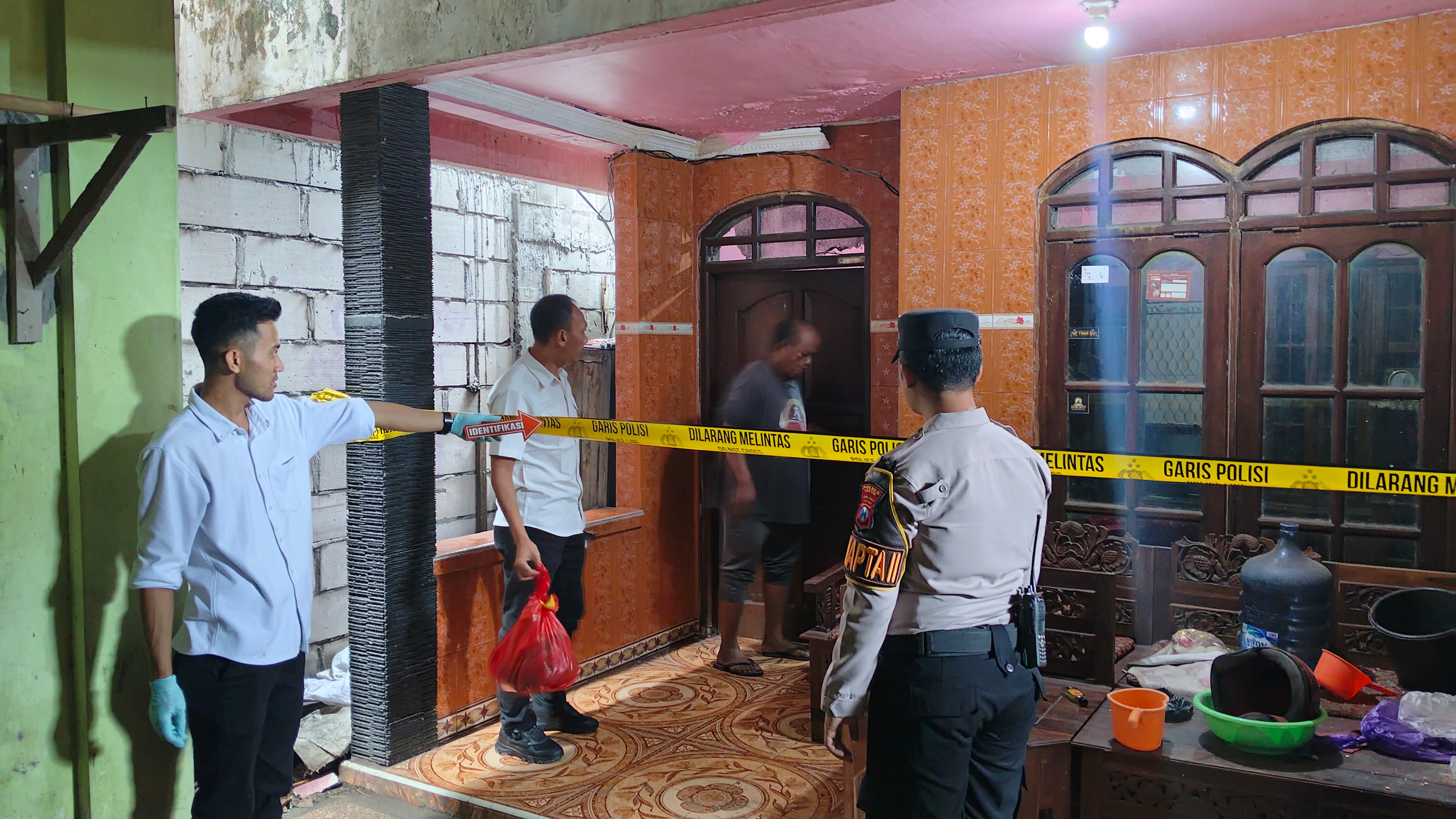 OLAH TKP : Anggota Polsek Kebomas saat melakukan olah TKP di rumah korban Jalan Dr. Wahidin Sudirohusodo, Desa Kembangan, Kecamatan Kebomas, Gresik.