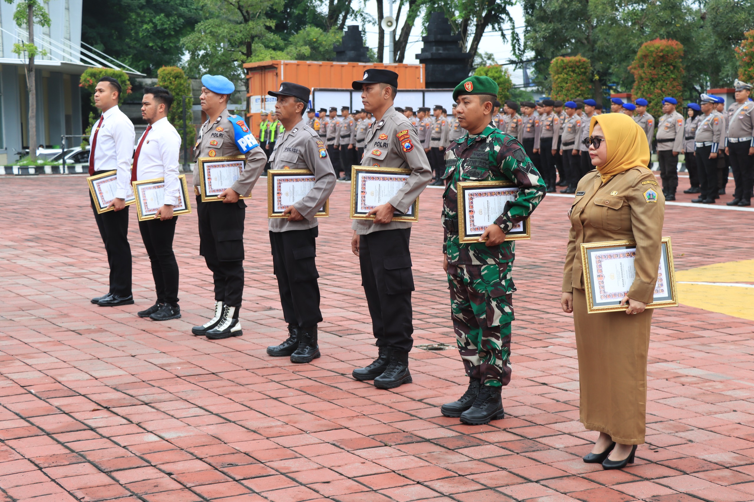 Penghargaan : Kapolres Gresik AKBP Ramadhan Nasution saat memberikan apresiasi penghargaan personel, anggota babinsa dan dua warga di Mapolres Gresik. 