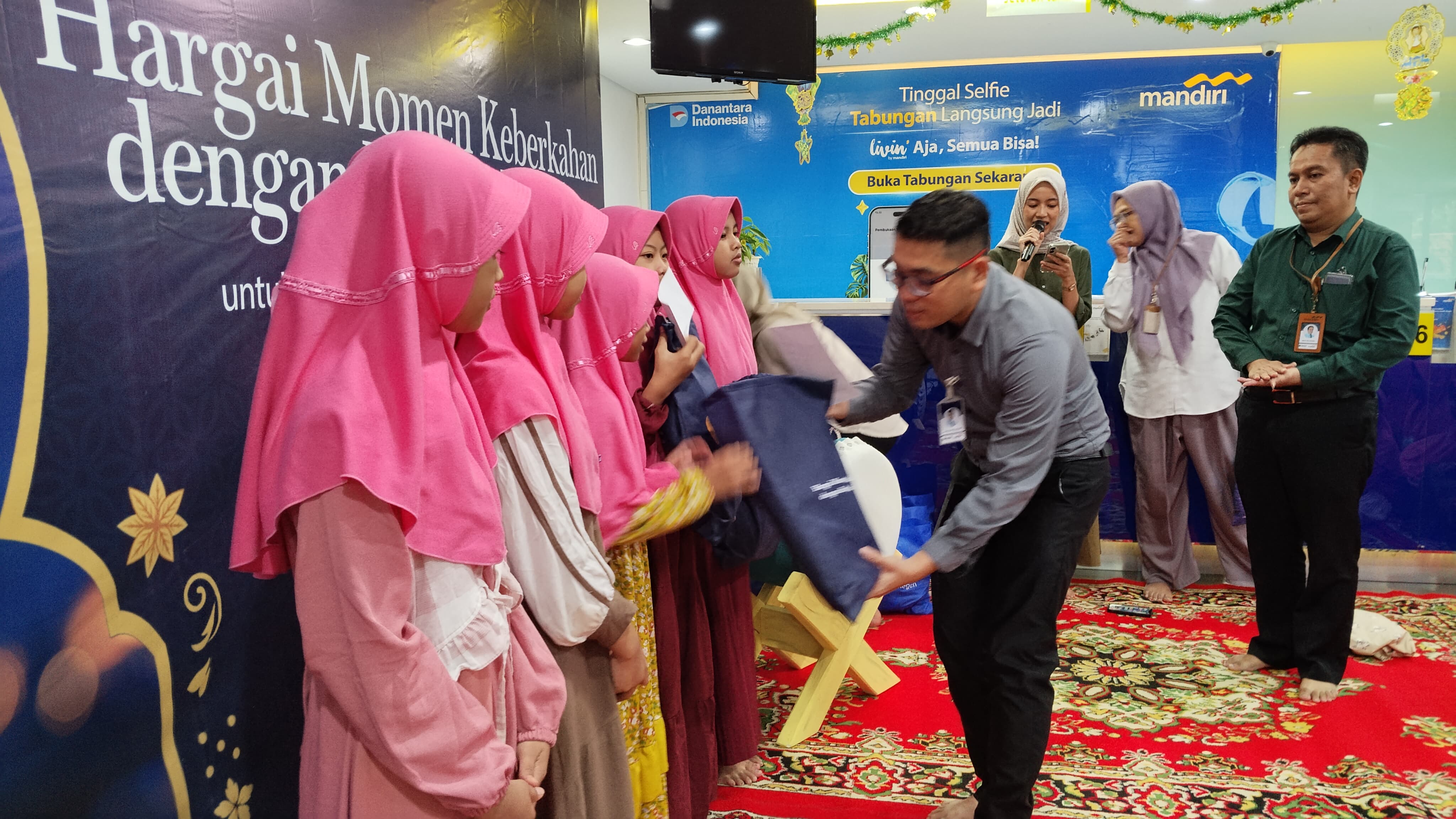 PEDULI : Area Head Bank Mandiri Gresik, Ken Kusuma Yodatama menyerahkan bingkisan santunan anak yatim.