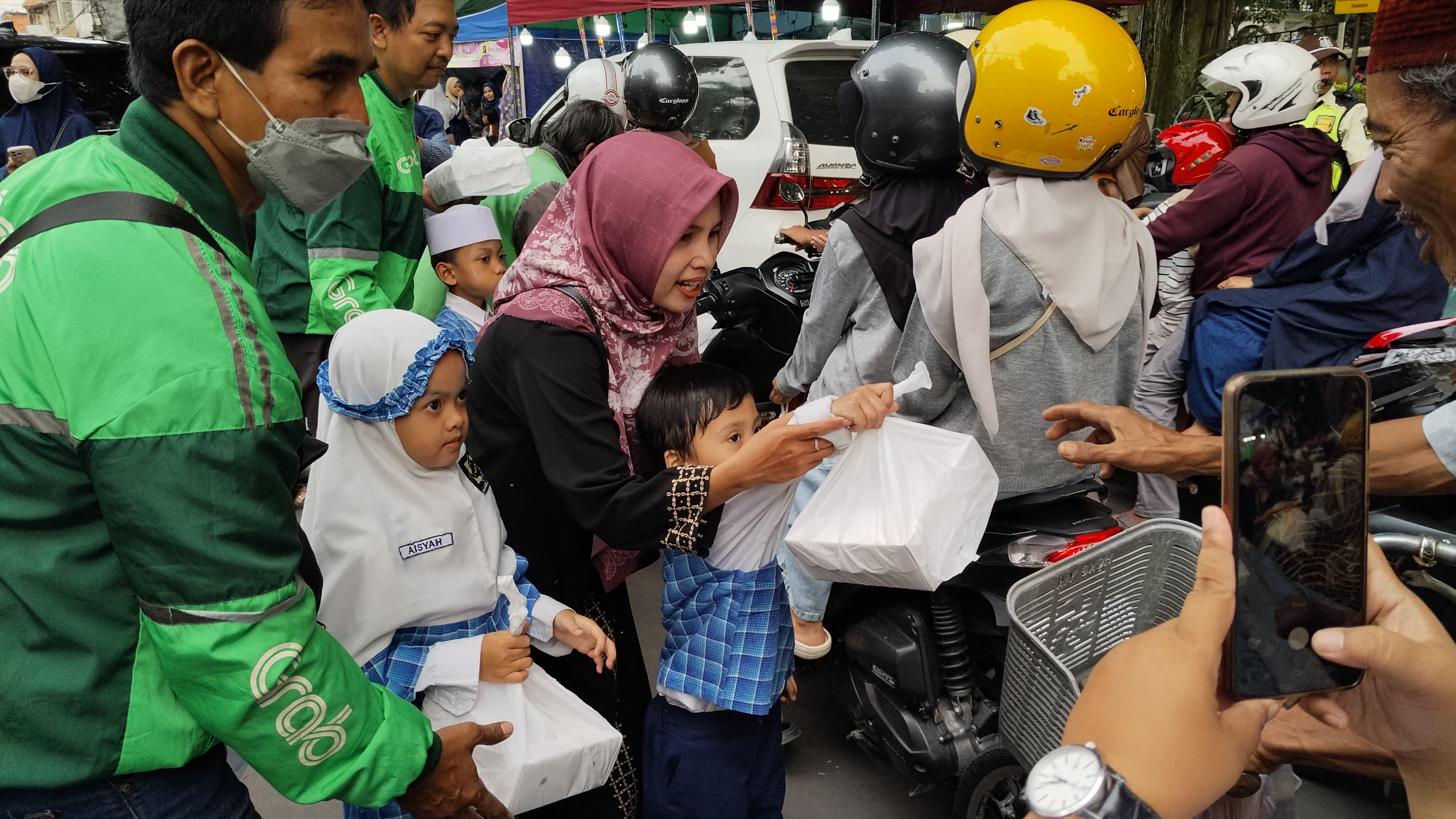 Siswa KITA YIMI bersama Guru dan pengemudi Ojek Online membagikan takjil gratis kepada warga di sekitar Alun-alun Gresik. 