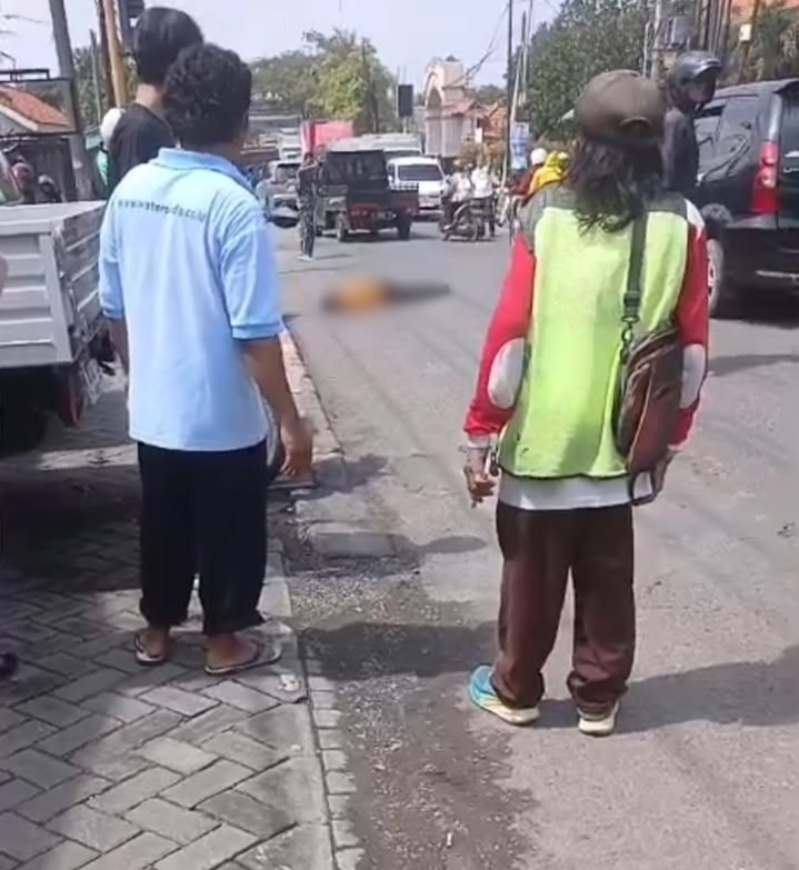 TEGELETAK : Seorang pengendara motor tergelatak di jalan usai terlibat kecelakaan di Jalan Raya Desa Tenaru, Kecamatan Driyorejo, Gresik.