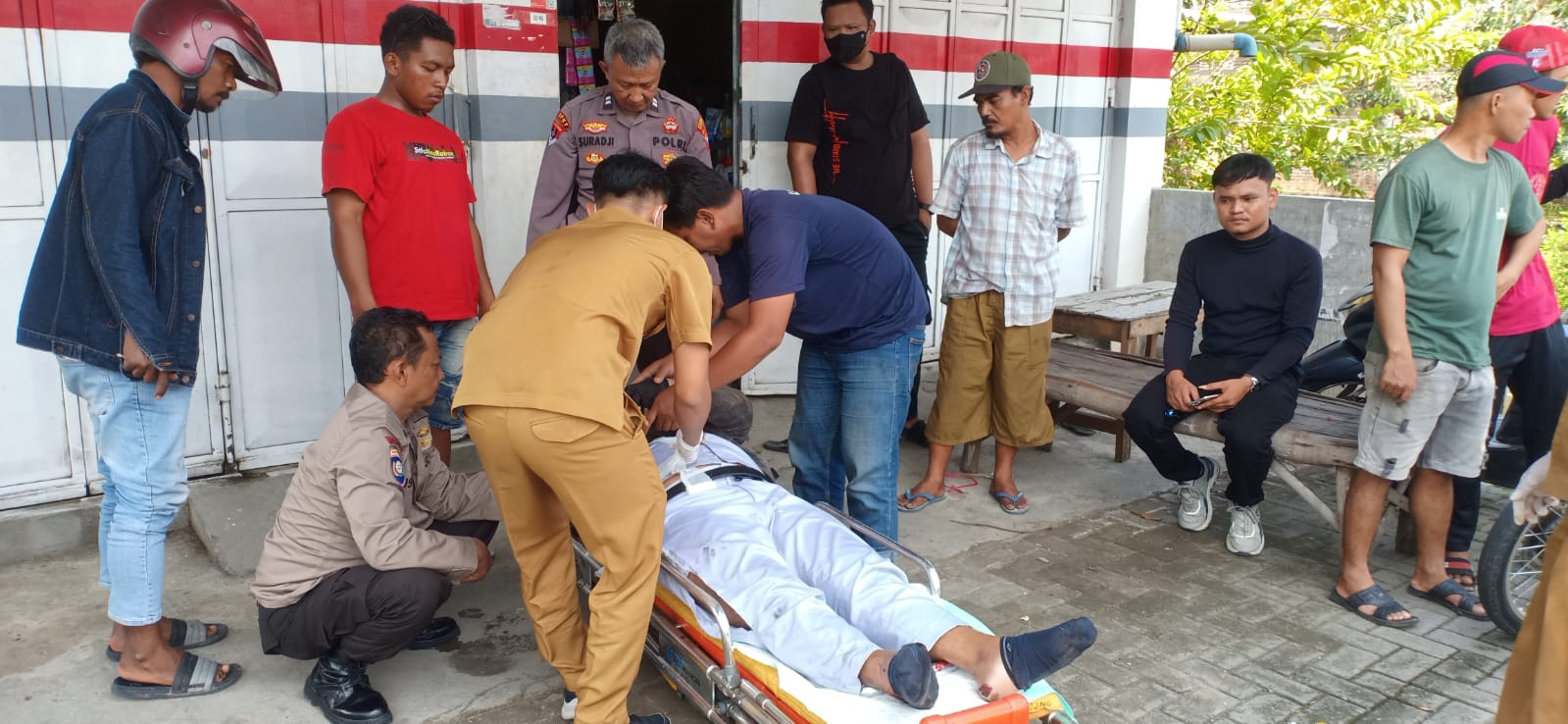 DIEVAKUASI : Anggota Polsek Benjeng dibantu tim medis dan warga mengevakuasi korban usai terlibat kecelakaan lalu lintas di Jalan Raya Kedungrukem, Desa Kedungrukem, Kecamatan Benjeng, Gresik.