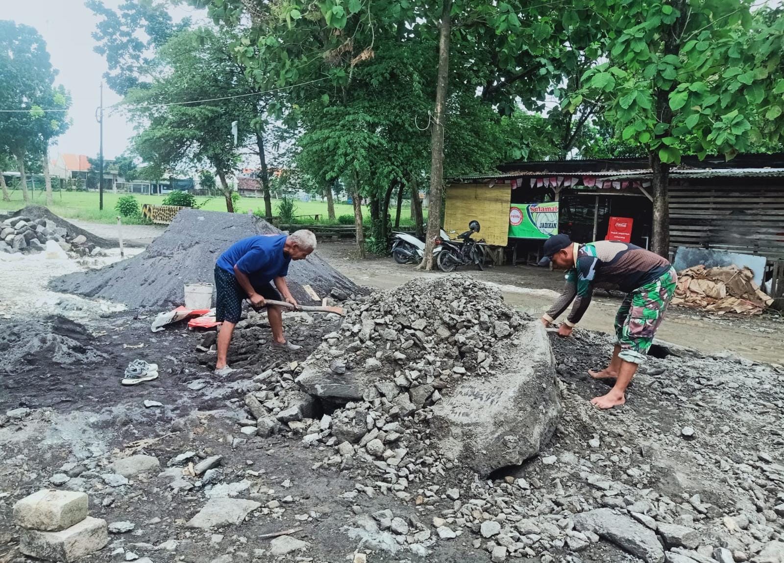GOTONG ROYONG : Babinsa bersama warga gigong royong dalam perbaikan jalan rusak. 