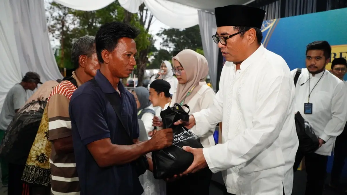 Direktur Utama Petrokimia Gresik, Daconi Khotob (kanan), menyerahkan bantuan sembako kepada masyarakat dalam kegiatan Safari Ramadan Pupuk Indonesia di Petrokimia Gresik. (Ist/Radar Gresik) 