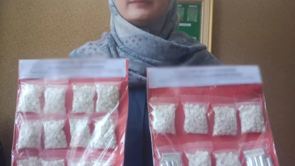 DIAMANKAN : Anggota Satreskoba Polres Gresik saat menunjukan barang bukti sebanyak 2.921 butir pil dobel LL dari tangan kedua tersangka berinisial KA dan ZA.