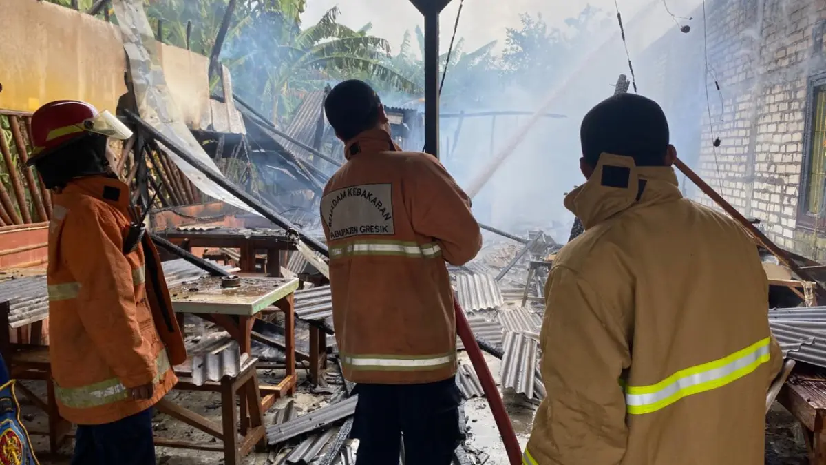 PEMADAMAN : Petugas Damkar Pos Dukun saat melakukan pemadaman kebakaran Warung Kopi di Desa Mojopetung, Kecamatan Dukun, Gresik. (Yudhi) 