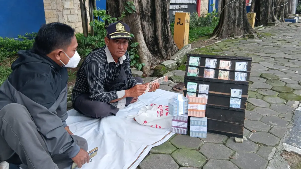 Penukaran : Salah satu penukar uang Hasan saat penukaran uang di depan kantor Damkar Gresik. (Fajar/Radar Gresik) 