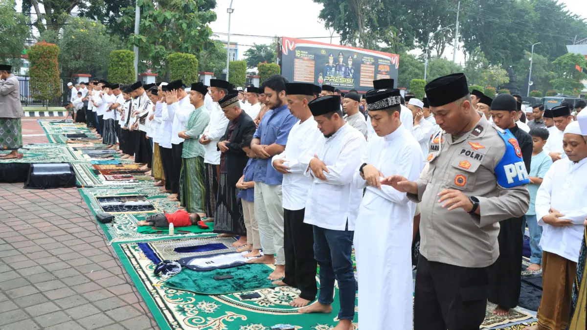 KHUSUK : Kapolres Gresik AKBP Ramadhan Nasution beserta jajaranya saat mengikuti Sholat Idulfitri 1447 H bersama warga di halaman Mapolres Gresik. (Yudhi/Radar Gresik) 