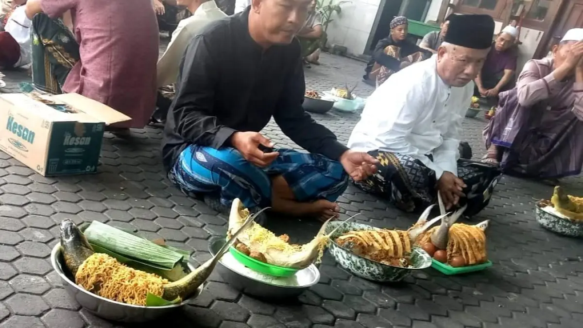 WUJUD SYUKUR: Sejumlah warga saat menikmati tradisi ambengan ikan bandeng di sebuah masjid. (Fajar/Radar Gresik) 