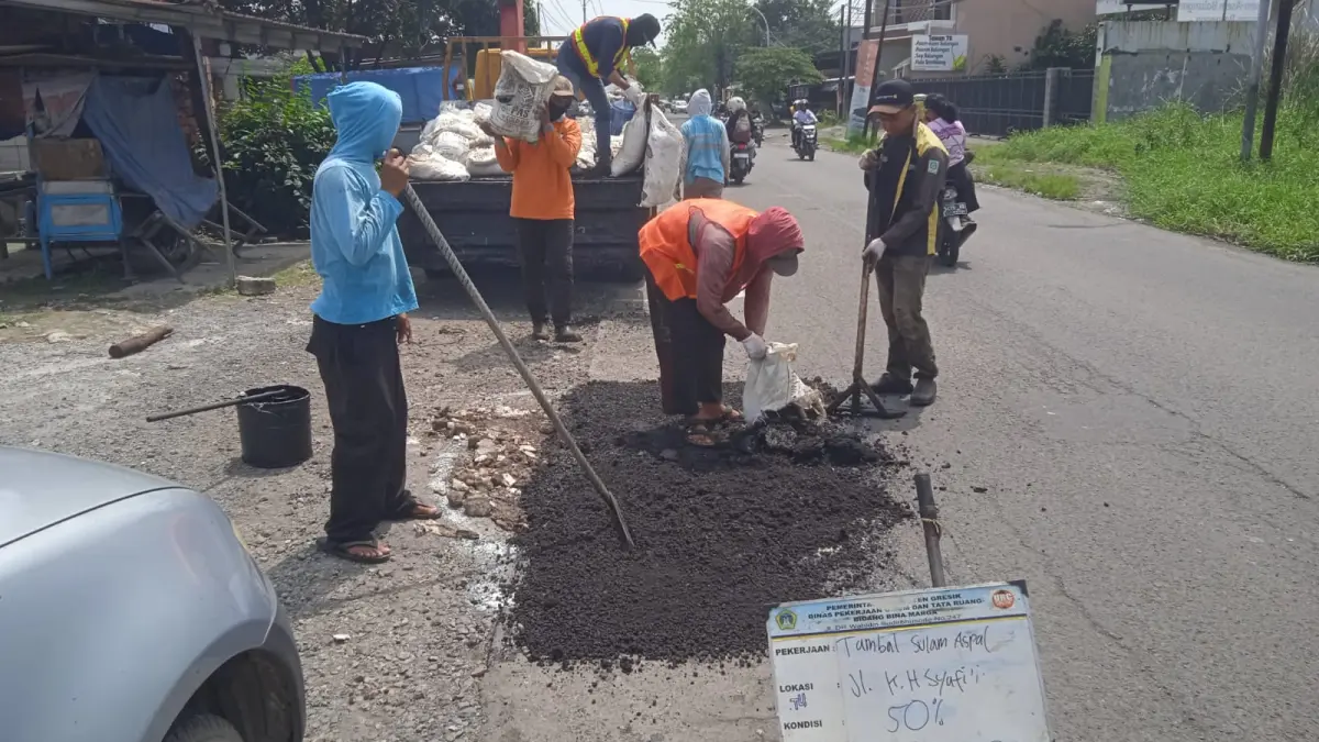TAMBAL : Petugas Satgas URC DPUTR Gresik saat tambal sulam di Kabupaten Gresik.