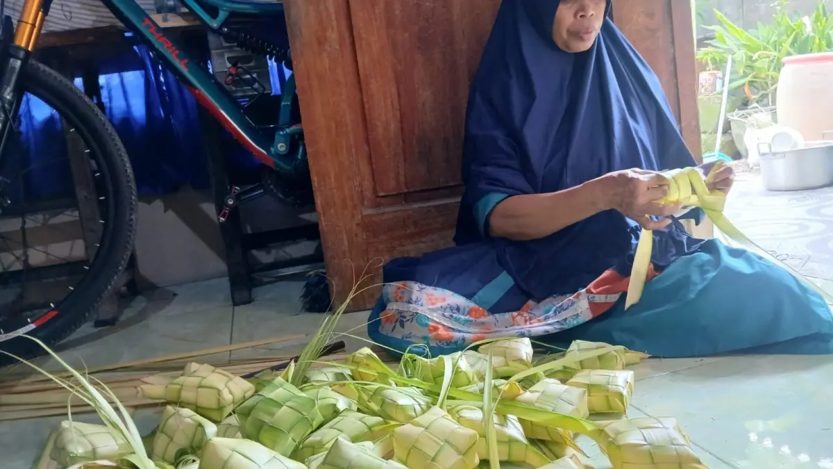 Cekatan : Salah satu warga Desa Suci, Kecamatan Manyar, Kabupaten Gresik, mulai menganyam janur untuk persiapan tradisi Kupatan. (Fajar/Radar Gresik) 