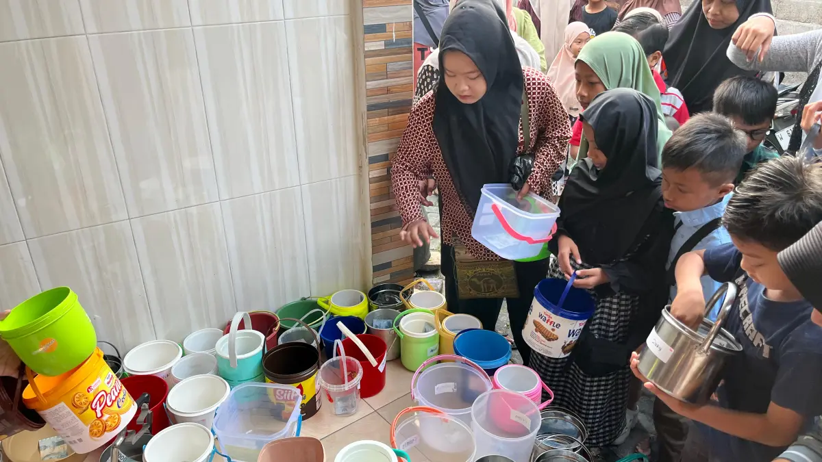 Berjejer : Anak-anak hingga remaja di Desa Randuagung menata rantang mengantre makanan. (Hani/Radar Gresik) 