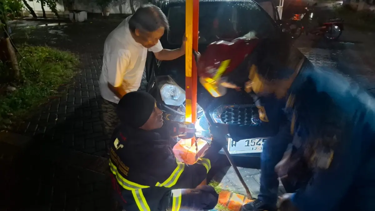 Terjebak Portal : Petugas Damkarla Gresik saat membantu evakuasi sebuah mobil saat terjebak di kawasan Gresik Kota Baru (GKB), (Ist/Radar Gresik) 