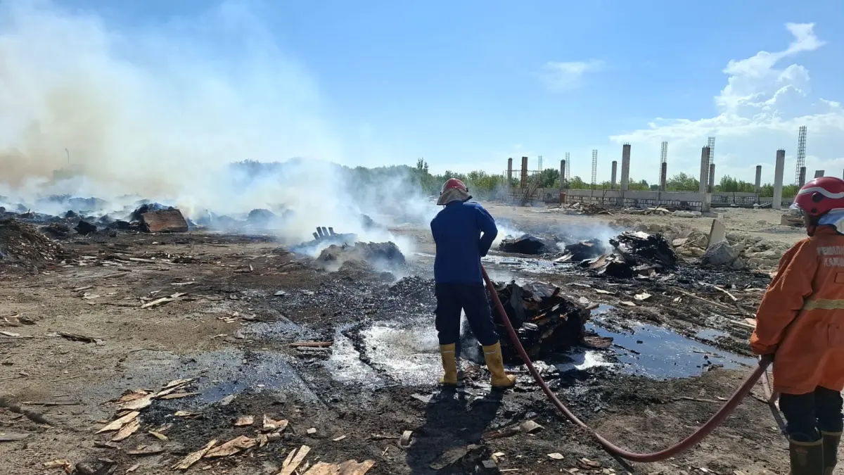 Pemadaman : Petugas Damkar Gresik saat melakukan pemadaman di area tumpukan limbah serpihan kayu di Jalan Mayjen Sungkono KM 2.8, Desa Prambangan. (Yudhi/Radar Gresik) 