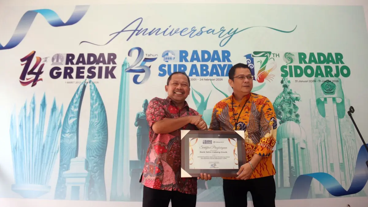 TUMBUH BERSAMA : Pemimpin Bank Jatim Cabang Gresik, Abdullah Basid, menerima penghargaan khusus dari Direktur PT Radar Media Surabaya, Lilik Widyantoro, atas keberhasilan mendorong Inklusi dan Ekonomi Daerah Kabupaten Gresik (31/03). (Satria/ Radar Surabaya)