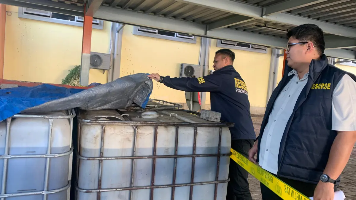 Timbunan : Kasatreskrim AKP Arya Widjaya dan Kanit Tipidter Iptu Komang Andhika menunjukkan barang bukti 10 ribu liter solar yang diamankan di Mapolres Gresik. (Ist/Radar Gresik) 