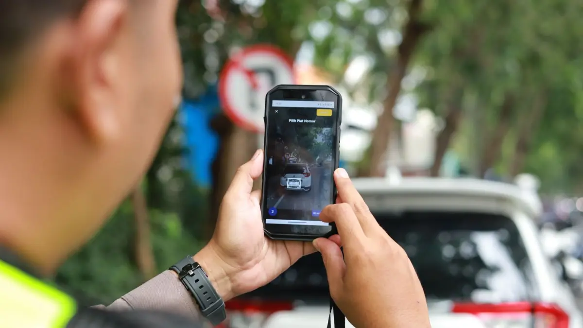 ETLE: Anggota Satlantas Polres Gresik saat melakukan penindakan melalui sistem ETLE Handheld terhadap pengendara di ruas jalan protokol Kabupaten Gresik. (Ist/Radar Gresik) 