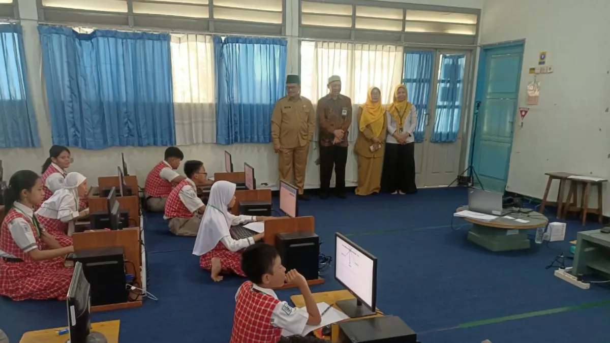Khidmat: Perwakilan Dispendik Gresik saat memantau jalannya Tes Kompetensi Akademik (TKA) di salah satu Sekolah Dasar untuk memastikan kelancaran evaluasi. (Dok/Radar Gresik) 