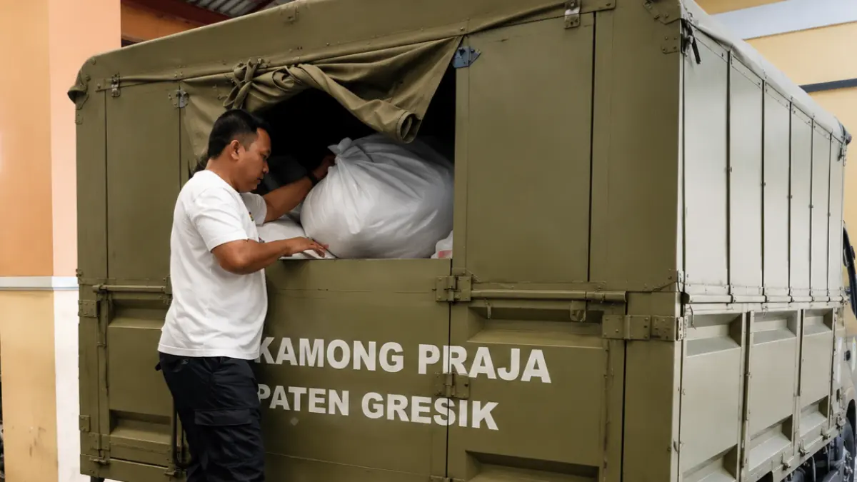 Personel Satpol PP membantu proses evakuasi barang bukti serta pengamanan enam orang sebagai barang bukti yang dibawa ke Kantor Bea Cukai Gresik menggunakan truk trailer operasional Satpol PP.