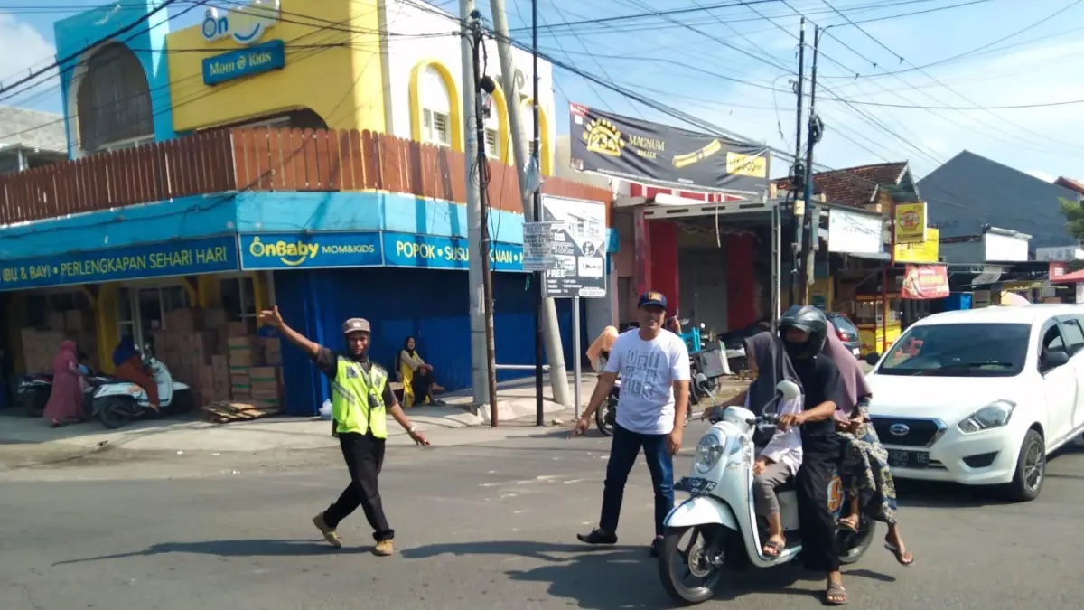 Terjun Langsung : Anggota Komisi IV DPRD Gresik, Sudadi, saat turun langsung memantau dan membantu mengatur lalu lintas di wilayah Kecamatan Balongpanggang. (Fajar/Radar Gresik) 