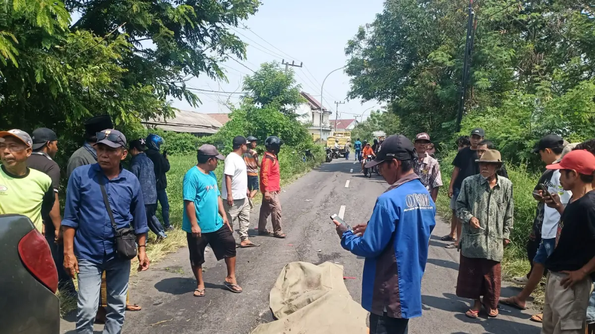 Petugas kepolisian dibantu warga saat melakukan evakuasi korban kecelakaan di Jalan Raya Banter, dekat gudang kayu, Kecamatan Benjeng, Gresik. (Ist/Radar Gresik) 