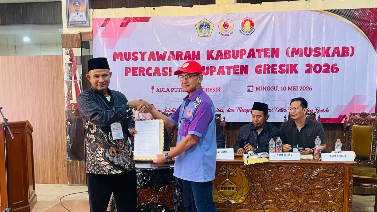 SIMBOLIS : Ketua Panitia Pelaksana, Sayuto (kiri) secara simbolis menyerahkan Surat Keputusan (SK) kepada Suharto sebagai Ketua Umum PERCASI Kabupaten Gresik terpilih untuk masa bakti 2026–2030. (Novia/Radar Gresik) 