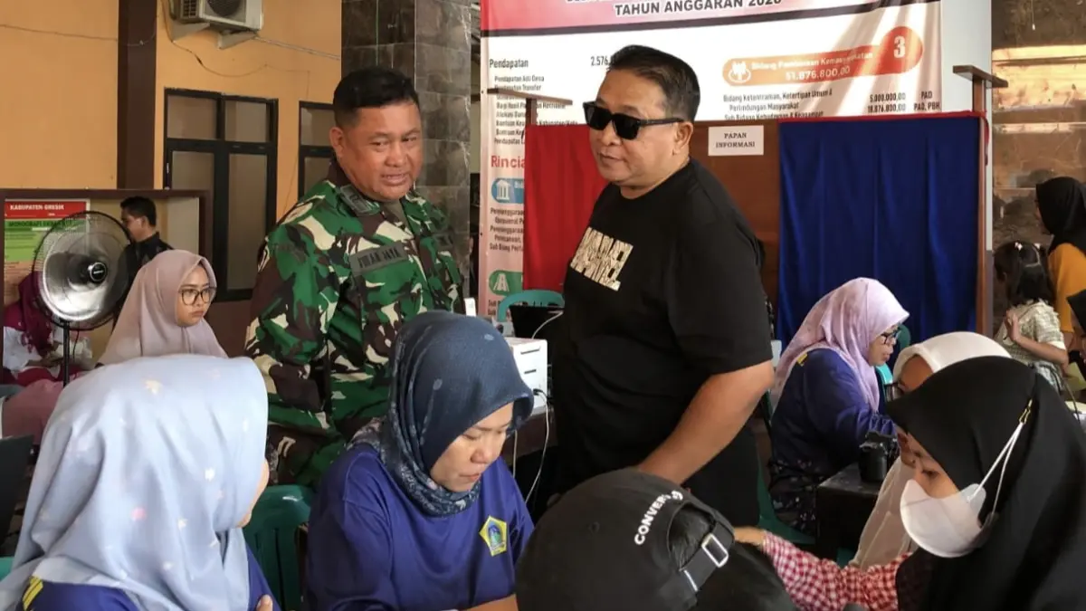 Jemput Bola: Petugas Disdukcapil Gresik saat melayani warga Desa Slempit, Kecamatan Kedamean, dalam program pelayanan administrasi kependudukan terpadu melalui TMMD 2026. (Ist/Radar Gresik) 