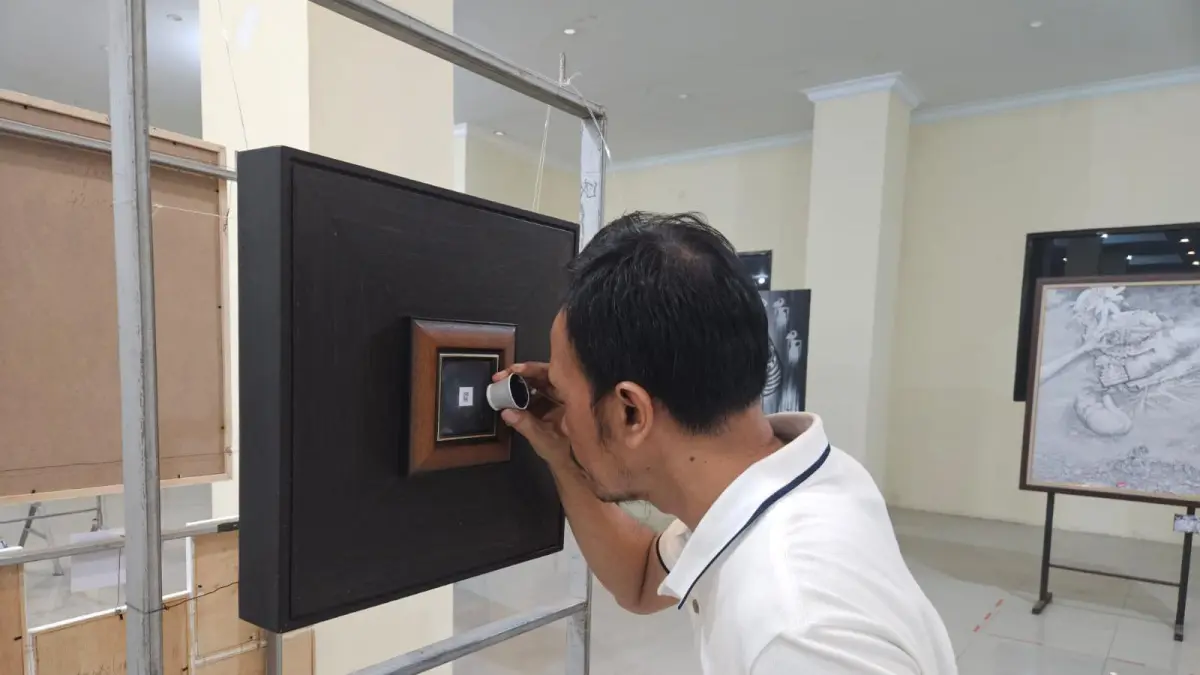Lukisan Gajah : Salah satu pengunjung menikmati karya seni lukisan yang terpajang di gedung pudak galeri Gresik. (Fajar/Radar Gresik) 
