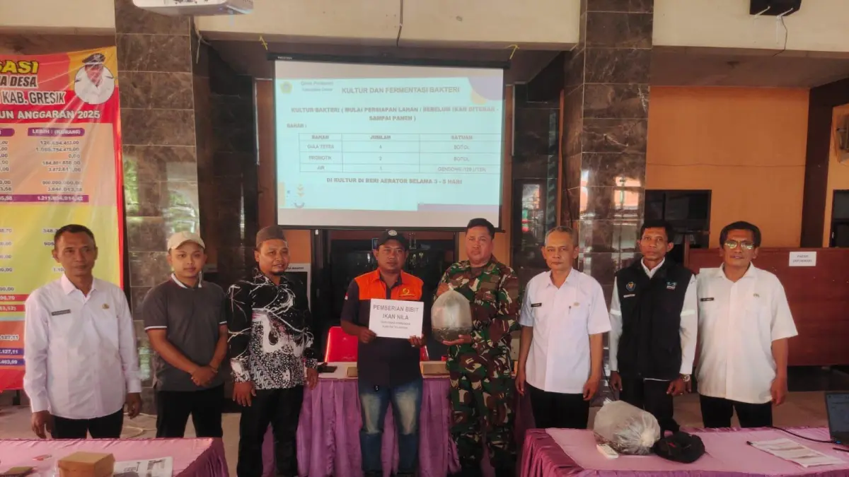 Ketahanan Pangan : Personel Satgas TMMD Ke-128 bersama perwakilan Dinas Perikanan Kabupaten Gresik saat menyerahkan bantuan ikan secara simbolis kepada warga di Balai Desa Slempit, Kecamatan Kedamean, Gresik. (Fajar/Radar Gresik) 