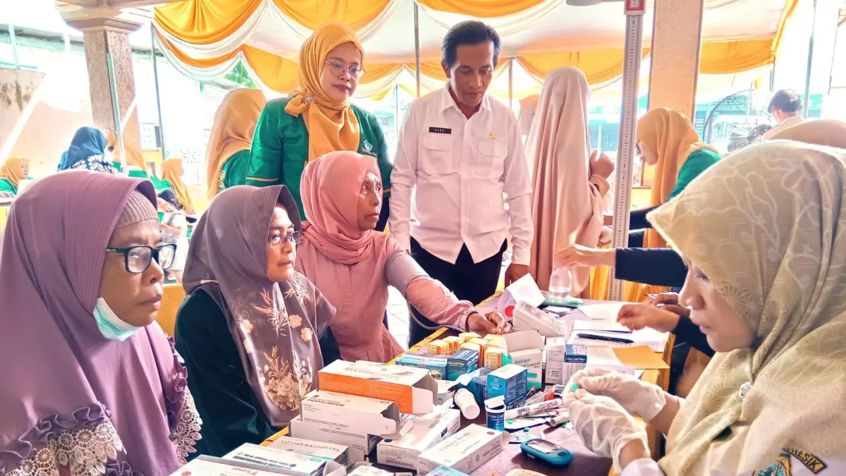 Meninjau: Kepala Desa Pranti, Hardi saat meninjau pemeriksaan kesehatan kepada warga di Balai Desa Pranti, Kecamatan Menganti, Gresik. (Ist/Radar Gresik) 
