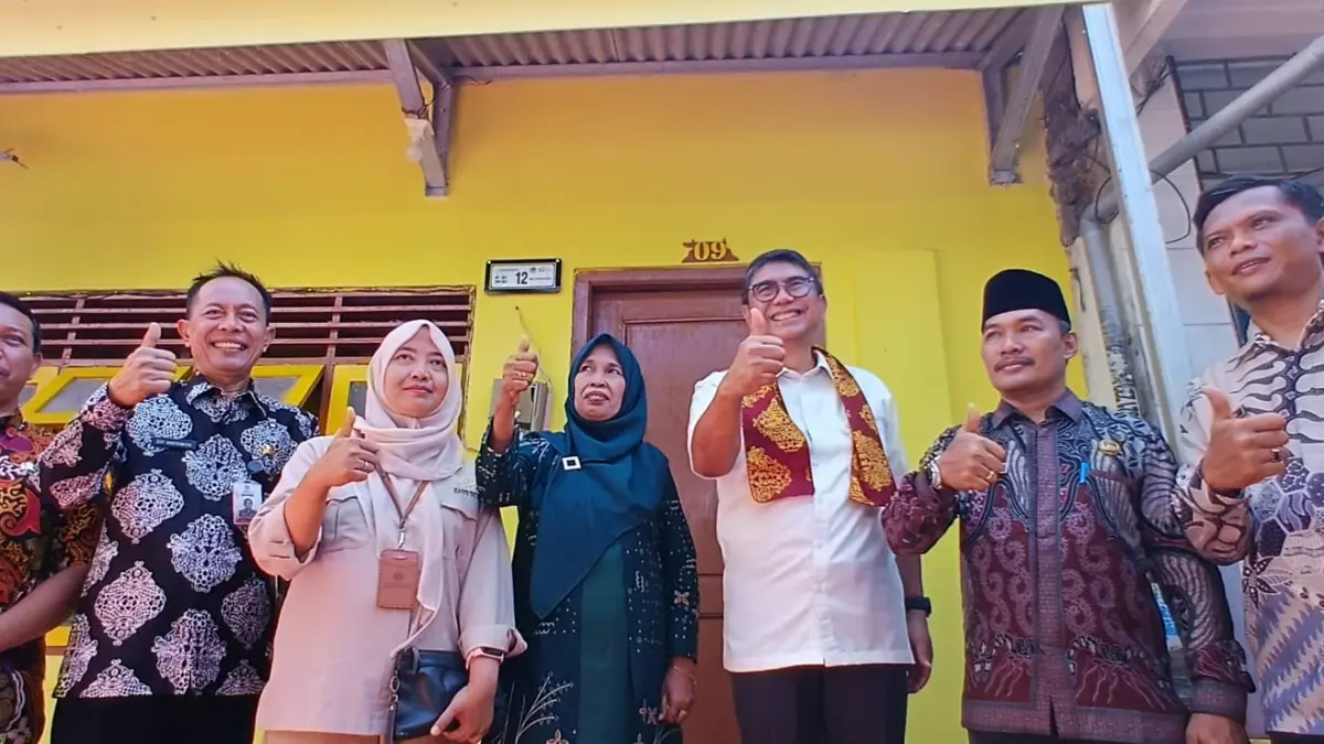 Sinergi : Kepala Bappeda Kabupaten Gresik, Edy Hadisiswoyo bersama Direktur Keuangan dan Manajemen Risiko PT SMF, Bonai Subiakto saat menggunting pita tanda peresmian bedah rumah di Desa Pulopancikan, Kecamatan Gresik. (Fajar/Radar Gresik) 