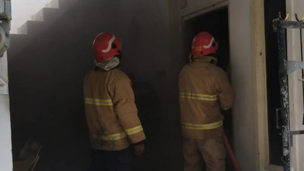 Pemadaman: Personel Dinas Pemadam Kebakaran dan Penyelamatan (Damkarla) Kabupaten Gresik saat berjibaku melakukan pembasahan di dalam rumah Perumahan GKA Manyar yang terbakar. (Ist/Radar Gresik) 