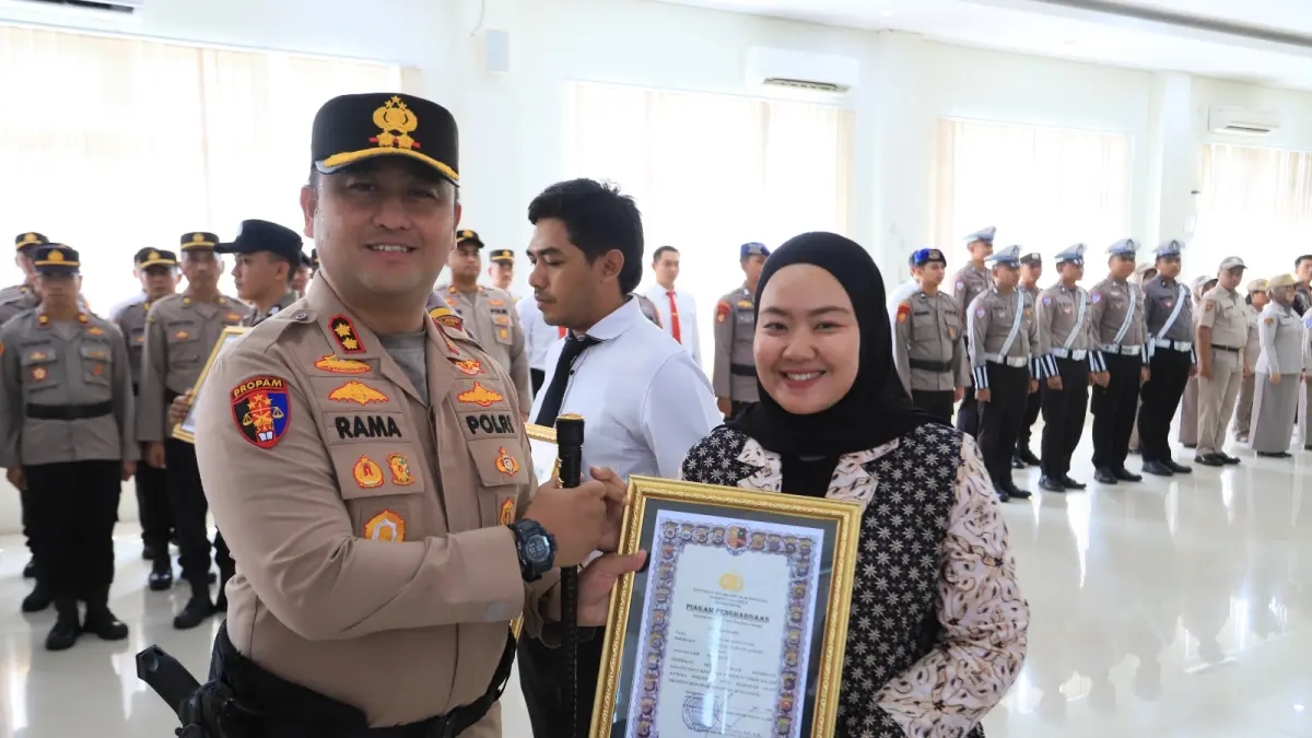 PENGHARGAAN: Kapolres Gresik AKBP Ramadhan Nasution saat menyematkan piagam penghargaan kepada salah satu warga yang berprestasi. (Yudhi/Radar Gresik) 