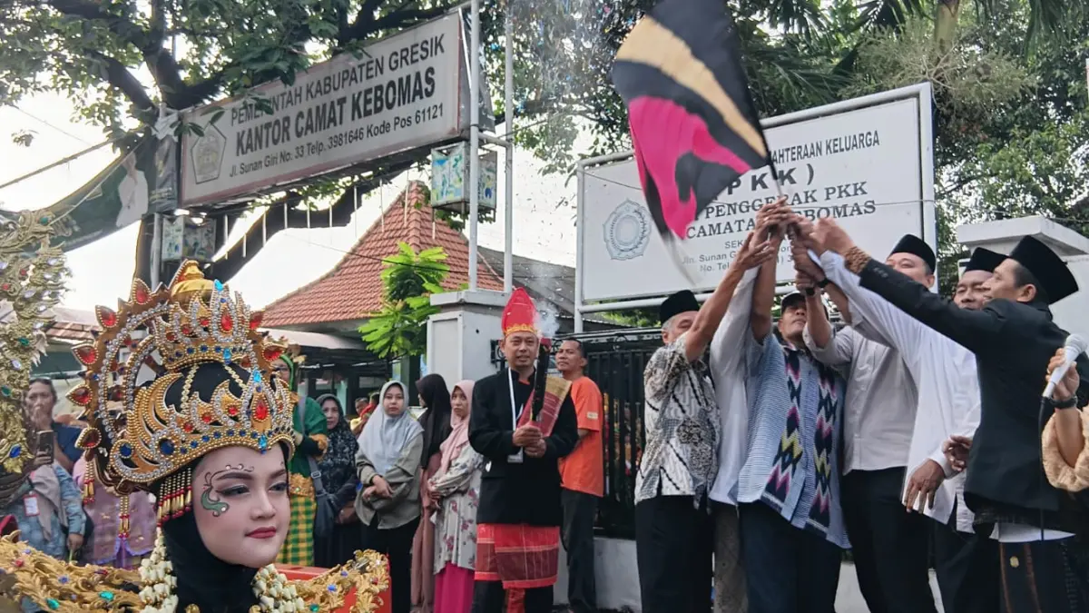 Melepas: Kepala MI Ma’arif Sidomukti Hery Antono bersama Camat Kebomas Tri Joko Efendi saat mengibarkan bendera start tanda dibukanya parade drumband dan kirab budaya. (Fajar/Radar Gresik) 