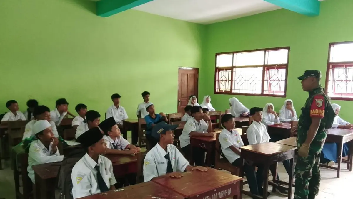 MASUK SEKOLAH: Babinsa Desa Sidogedungbatu, Serda Mirsal, saat berdialog akrab dengan para siswa MTs Ma