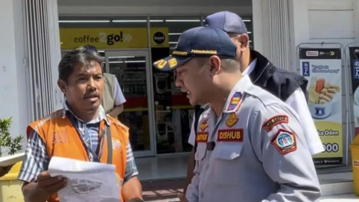 PENGECEKAN: Kepala UPT Pengelolaan Prasarana Perhubungan Wilayah Kota Dishub Gresik Muhammad Mansyur Arif saat melakukan pengecekan kelengkapan Surat Perintah Tugas (SPT) kepada jukir di kawasan niaga Gresik. (Fajar/Radar Gresik) 