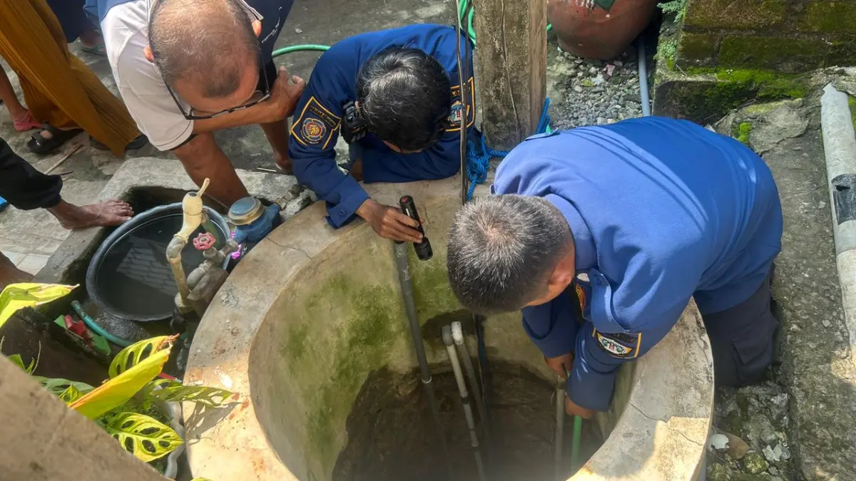 DIEVAKUASI : Petugas Damkar Gresik saat melakukan evakuasi kucing yang terjebak di dalam Sumur di Desa Lowayu, Kecamatan Dukun, Gresik. (Ist/Radar Gresik) 